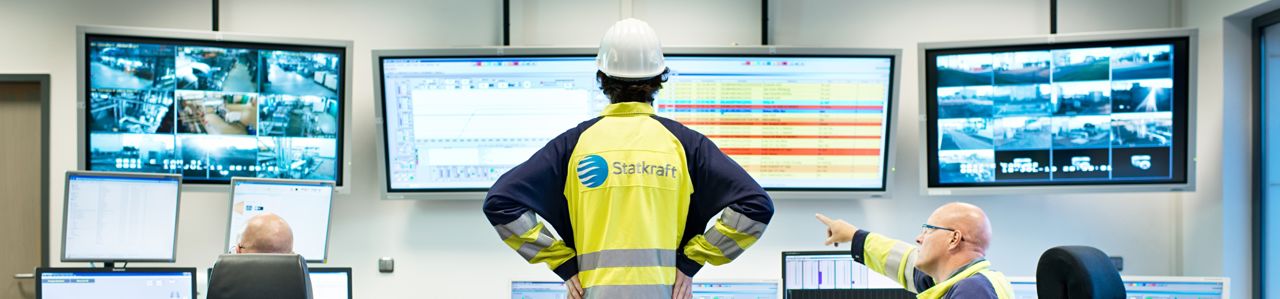 Tre arbetare vid det centrala kontrollrummet i ryggsäcken