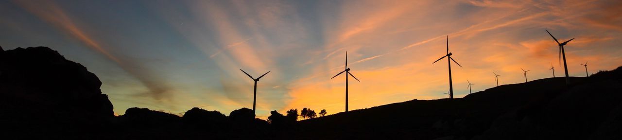 Un amanecer detrás de un parque eólico
