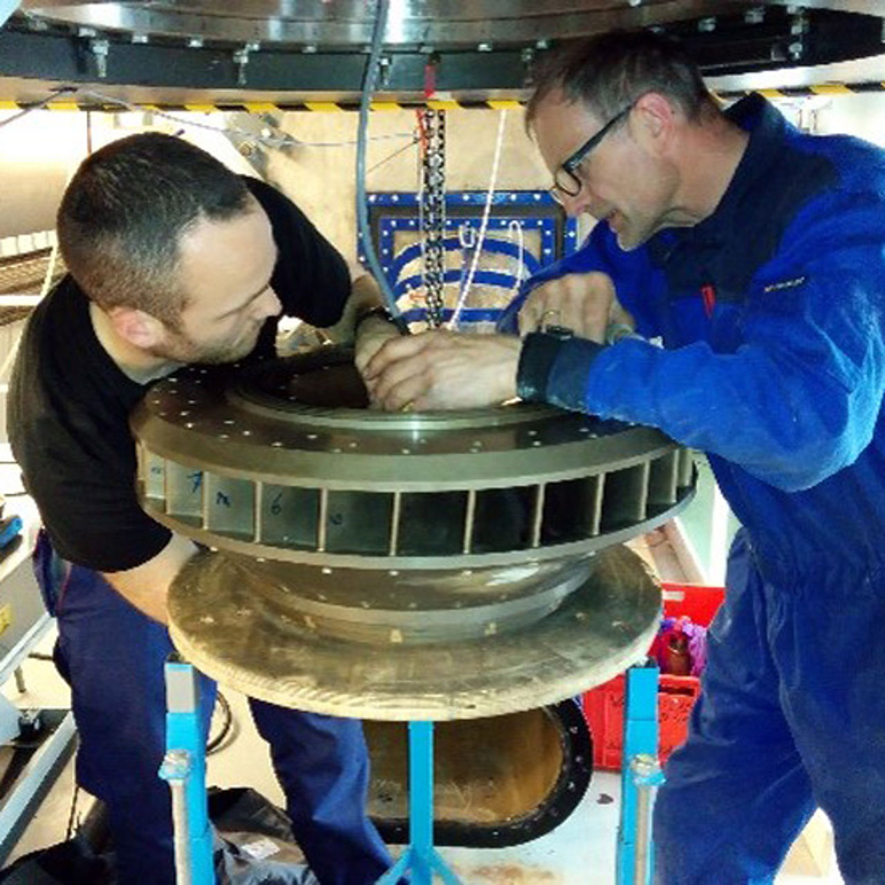 Men studying turbine wheel