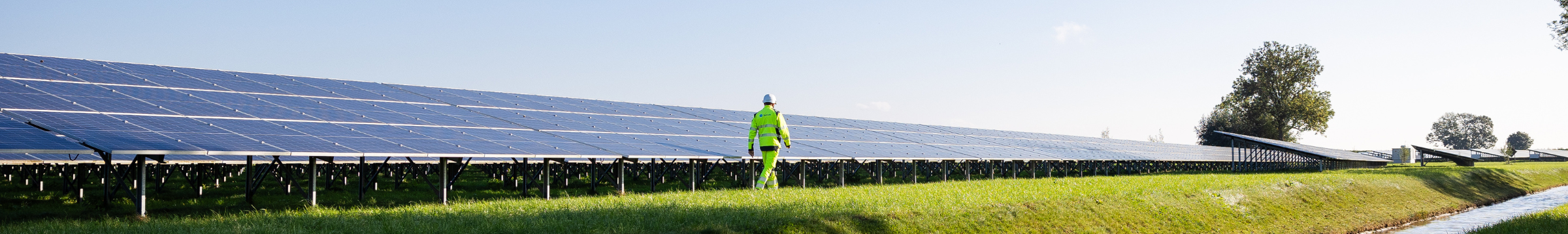 Man walking next to a solar panel