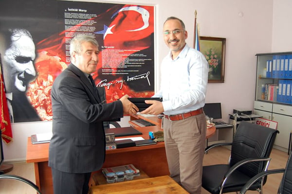 Bahadir Sezegen (right), who coordinates environmental and social issues for Statkraft in Turkey, hands over used and recycled Statkraft computers to Mahmut Karakaş, manager at Gemici Primary School in the city of Osmancik. 